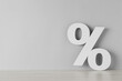 © New Africa - Paper percent symbol cutout on wooden table against light grey background. Space for text