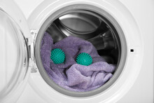 Green dryer balls and towel in washing machine drum