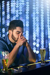 Poster - Another night hell never get back. Shot of a young man looking stressed out while having drinks at a bar alone.