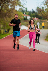 Wall Mural - Athletic couple of sprinters run on running track at stadium, success