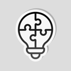 Wall Mural - Puzzle lightbulb, team idea, simple icon. Linear sticker, white border and simple shadow on gray background