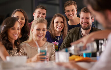 Poster - Drinks and a show. Shot of a happy group of friends having drinks at a bar together.