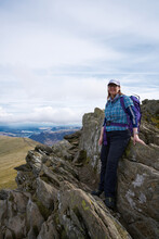 A Female Hiker On Striding Edge, Helvellyn, Shot In Portrait Looking Towards The Camera