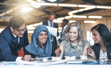 Canvas Print - Its all coming together now. Shot of a team of successful businesspeople working with a scale model of a building in their office.