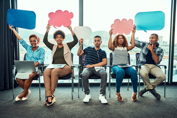 Aufkleber - They are one live bunch. Portrait of a cheerful young group of work colleagues seated next to each other while holding up signs inside of the office during the day.