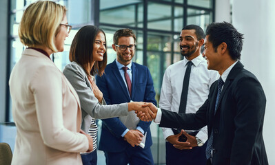 Poster - Its an honour to be working alongside the best. Shot of businesspeople shaking hands in an office.