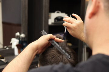 Sticker - Professional hairdresser cutting man's hair in barbershop, closeup