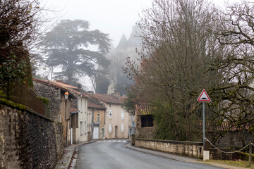 Wall Mural - Street of Verteuil sur Charente in foggy winter day, Charente, France