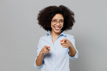 Young fun employee business corporate lawyer woman of African American ethnicity in classic formal shirt work in office point index finger camera on you say do it motivate isolated on grey background.