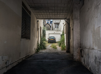 Wall Mural - Biarritz, France - July 28 2016: Black car parked in an overgrown backyard.