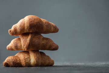 Wall Mural - Close up shot of a bunch of homemade croissants on a dark background.