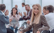 © ASDF - smiling young woman sitting at table in conference room
