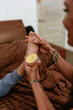 © Marcos - Hispanic Mother putting cream, ointment or balm to her son on the foot on bed at home in Mexico Latin America