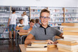 © JackF - Portrait of cheerful teenage boy reading books in college library
