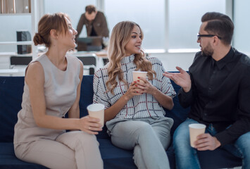 Poster - business team is discussing something sitting in the office lobby