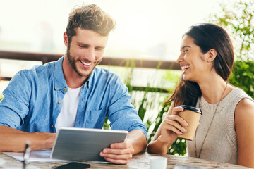 Wall Mural - Online is the best place to source inspiration. Shot of two businesspeople using a digital tablet together outdoors.