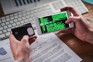 Fototapete - Setting up state of the art security features. Shot of an unidentifiable programmer holding his credit card while programming on his smartphone.