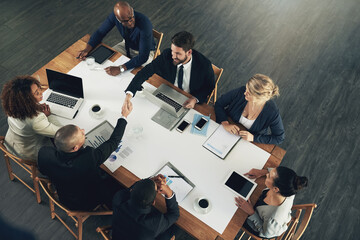 Poster - Teaming up for more productivity. High angle shot of a team of businesspeople working around a table in the office.