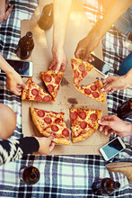 Good Food, Great Friends, Glorious Times. Cropped Shot Of A Group Of Friends Eating Pizza While Having A Picnic.