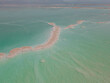 Aerial shoot of Salty islands of Dead Sea among mirror smooth water with Jordan mountains on the horizon. Seascape, Nature background. Israel