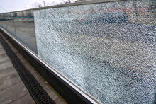 Broken Glass Fence, Damaged Glass Panel With Banisters. Broken Guard Rail On Office Terrace. Steel Railing With Glass Panel, Cracks On Broken Tempered Glass. Broken Hardened Glass. Vandalism Concept