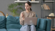 © stockbakers - Woman with Laptop having Wrist Pain on Sofa