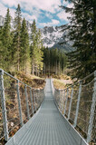 Fototapeta Mosty linowy / wiszący - lange Hängebrücke aus Stahl mit schneebedeckten Bergen von Südtirol im Hintergrund in den Dolomiten in Südtirol