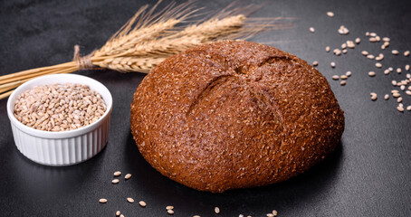 Fresh baked brown bread with ears and grains of wheat