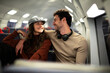 © JustLife - Loving couple travel by train. Happy woman and man talking while sitting in the train