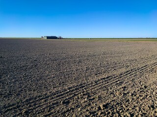 Wall Mural - Blue sky above the fields with farm in the distance