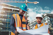 Running a job site is a joint effort. Shot of a young man and woman going over building plans at a construction site.