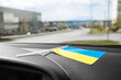 canvas print picture - Ukrainian flag on glass inside the car