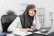 © Pixel-Shot - Tired Muslim secretary working in office