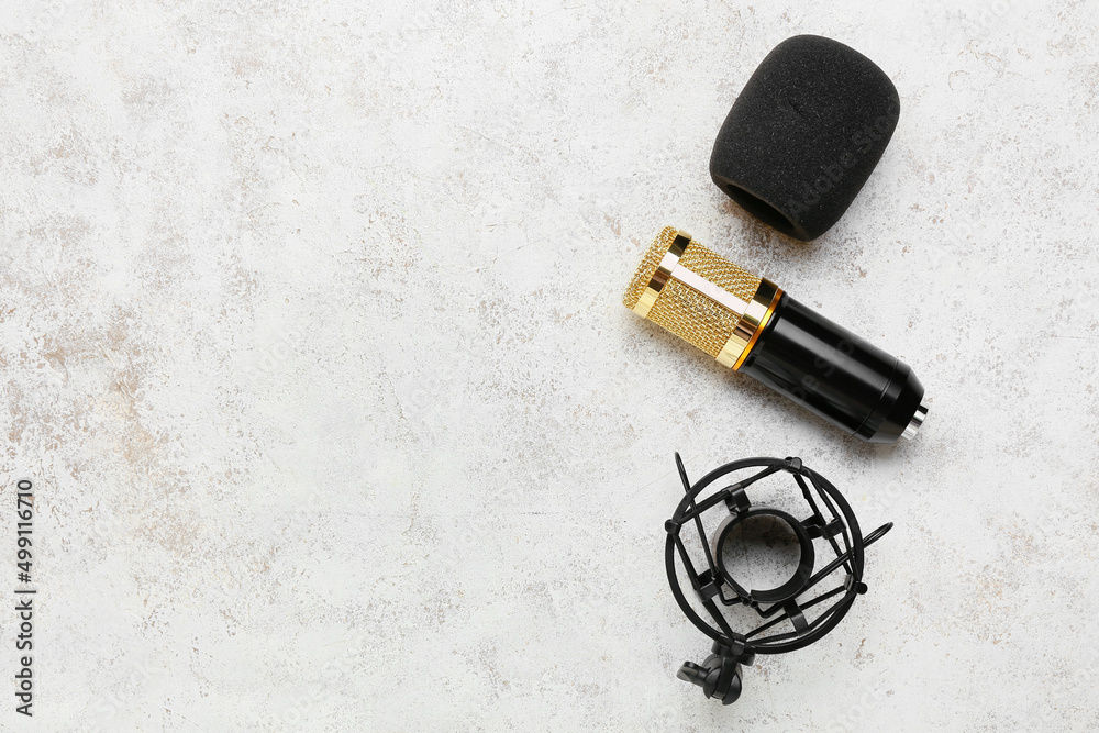 Modern microphone with stand on light background