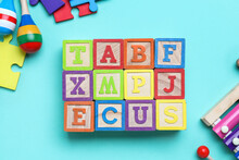 Wooden Cubes With Letters And Baby Toys On Blue Background