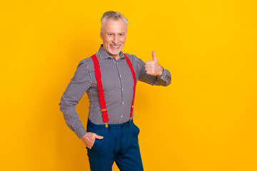 Sticker - Portrait of attractive cheerful man wearing costume showing thumbup ad agree isolated over bright yellow color background