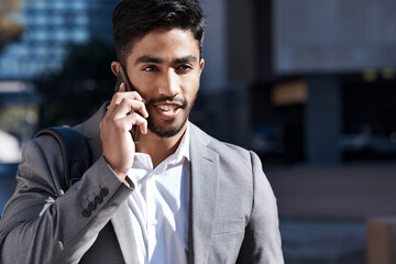 Poster - Business calls on the go. Shot of a young businessman on a call in the city.