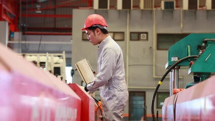 Wall Mural - Factory engineer worker operating metal sheet roof machine at Heavy Industry Manufacturing Factory. worker in safety hardhat at factory industrial facilities