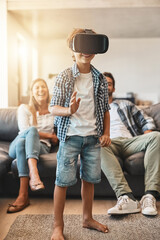 Sticker - Stepping into a virtual world. Shot of a little boy using a virtual reality headset at home with his parents in the background.