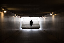 Man Walking In Dark Underground Tunnel. Stranger Anonymous Person. Unknown Person In Subway. Horror And Thriller Concept. Light At End Of Tunnel.