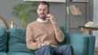 © stockbakers - Man Talking on Phone on Sofa