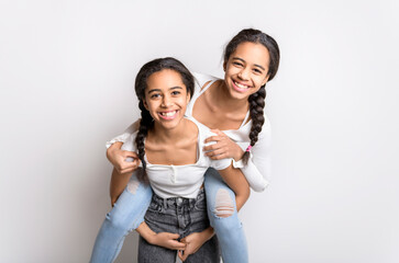 Wall Mural - Adorable black twin teen girl on studio white background