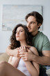 © LIGHTFIELD STUDIOS - man in green t-shirt hugging sensual woman at home.