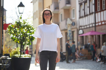 Wall Mural - Woman in white blank t-shirt wearing glasses in the city