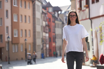 Wall Mural - Woman in white blank t-shirt wearing glasses in the city
