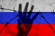 Russia sanctions. Abstract russian flag behind barbed wire fence with reaching out hand. War aggression conflict concept. Russians prison