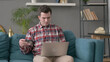 Man with Unsuccessful Online Payment on Laptop on Sofa 