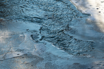 Wall Mural - The ice cover of the river washed by stormy water. Ice is opened on a stormy mountain river, ice, snow, stormy river.