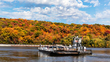 A Ferry Carries Cars Across The Mississippi River From Missouri To Illinois And Autumn Rural Countryside Landscape With Trees With Colorful Fall Leaves On A Hillside.
