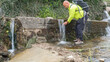 © MiguelAngel - Hiker and adventurer man fetches water with his hands in a fountain.